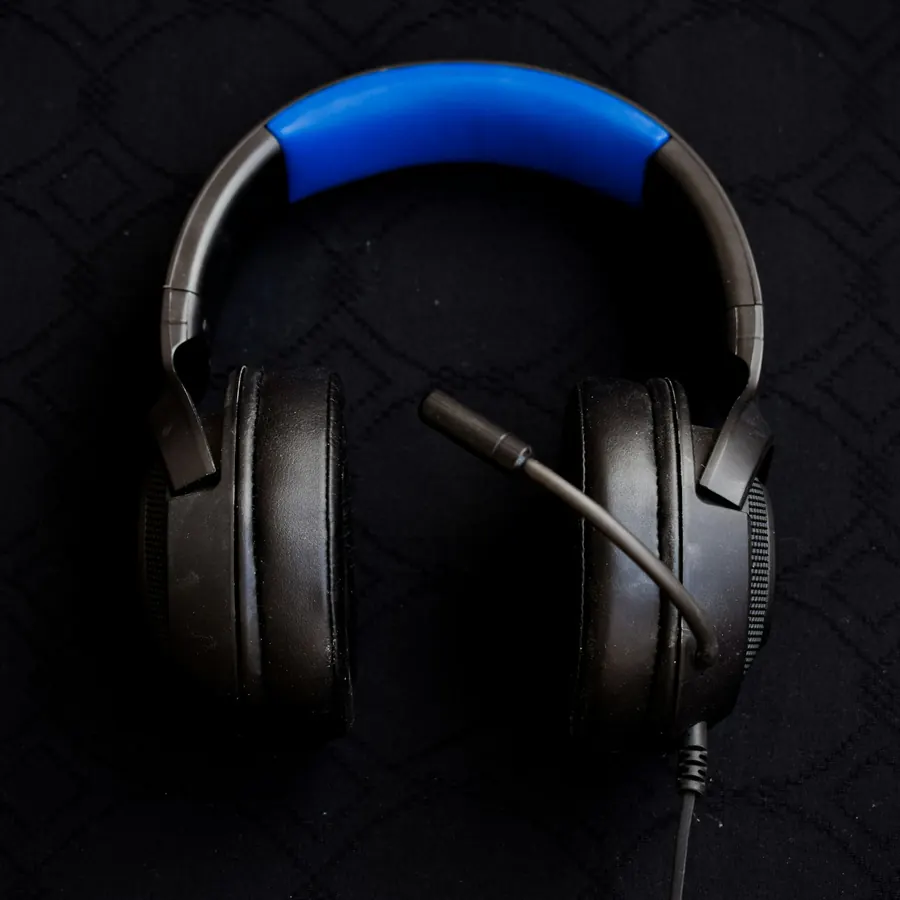 Audífonos gamer negros con diadema azul y micrófono