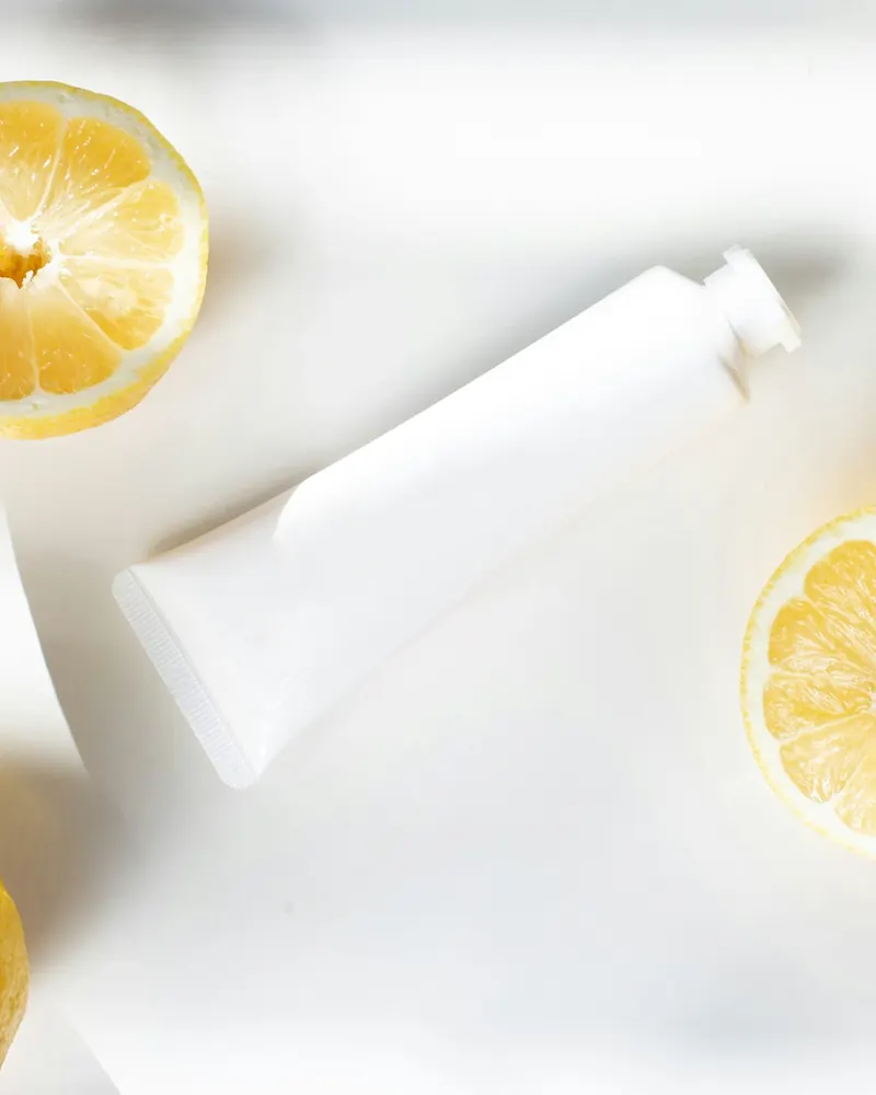 Tubo blanco de gel junto a rodajas de limón