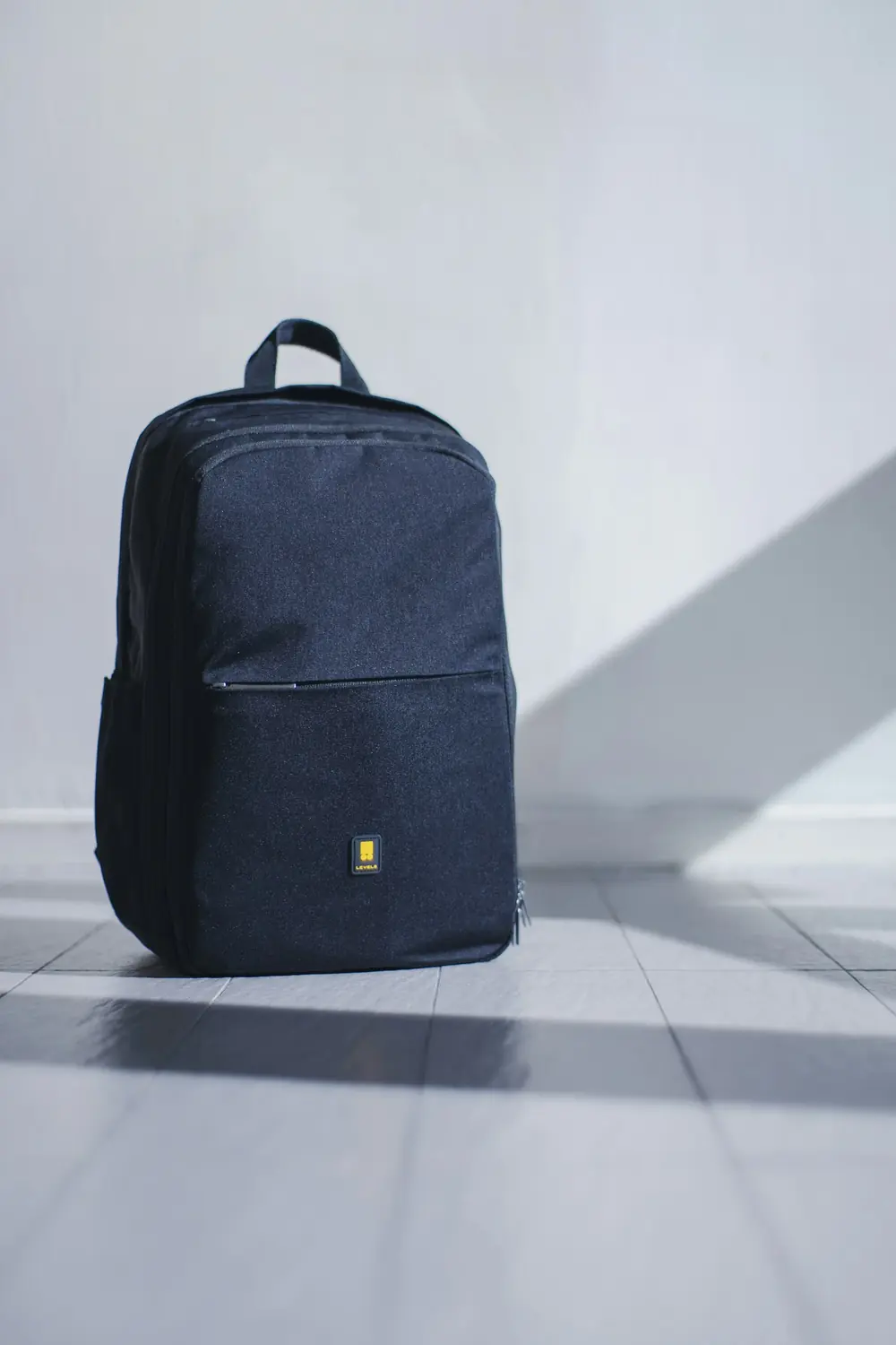 Mochila urbana azul noche apoyada en el piso