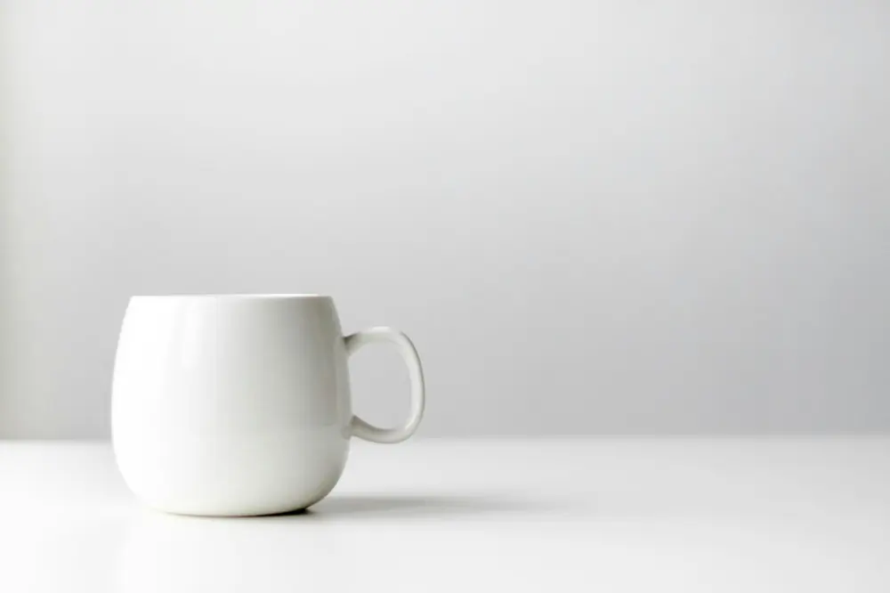 Taza de cerámica blanca sobre una mesa blanca