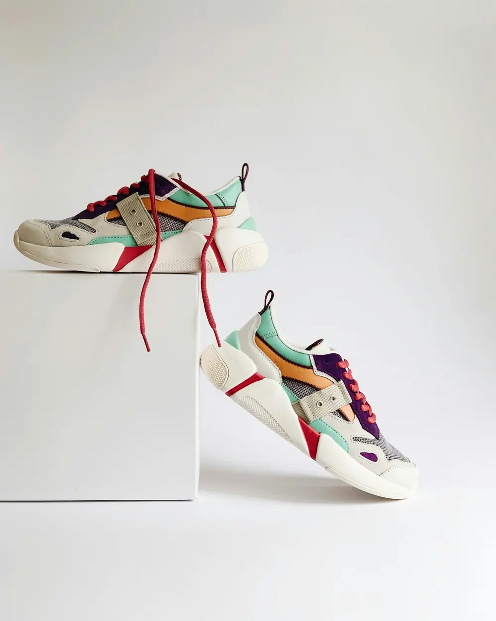 Par de zapatillas blancas con detalles en verde menta, naranja y lila